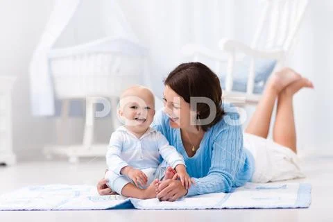 Mother and baby playing on the floor Stock Photos