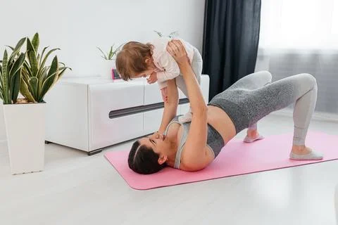 Mother and baby taking a break from working out. New mom bonding with her baby Stock Photos