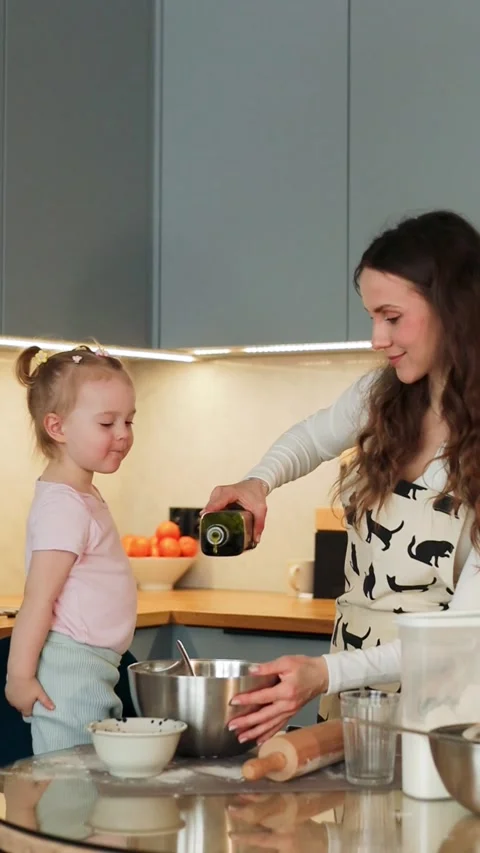 Mother and Child Adding Oil to Dough in Family Kitchen Stock Footage 328260559