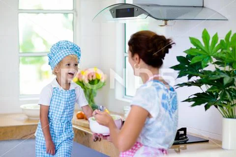 Mother and child cook. Mom and kid cook in kitchen Stock Photos