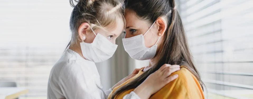 Mother and child with face masks indoors at home, Corona virus and quarantine Stock Photos