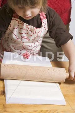 Mother and child rolling out puff pastry Stock Photos
