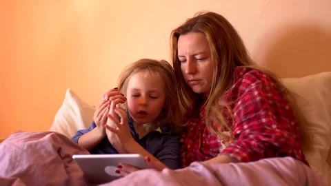 Mother and child using tablet in bed before going to sleep Stock Footage 73549728