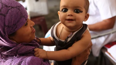 Mother and child wearing eye makeup together in rural India villageStock Footage