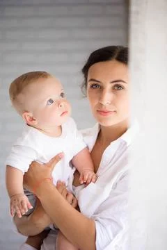 Mother and child in a white room. Mom and baby boy in diaper pla Stock Photos
