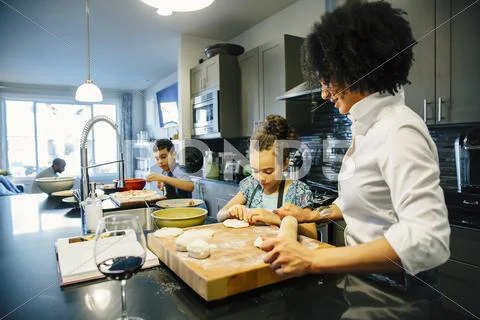 Mother And Children Baking In Kitchen