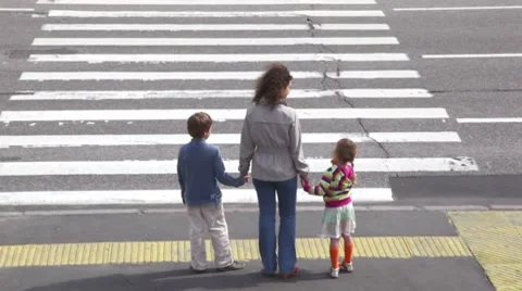 Mother and children, cross road at pedestrian crossing after car drove Stock Footage