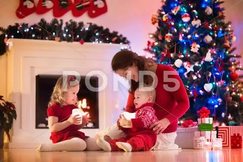 Mother and children at home on Christmas eve Stock Photos