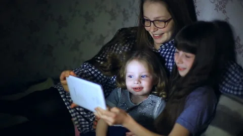 Mother and children with a tablet computer at home watching cartoons and playing Stock Footage 87776025