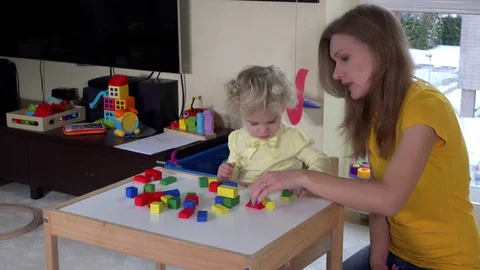 Mother and cute daughter play with wooden pads. fine motor skills education. 4K Stock Footage 130006953