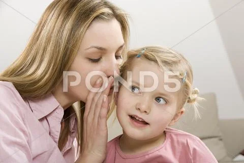 Mother and daughter (3-4) whispering, close up Stock Photos