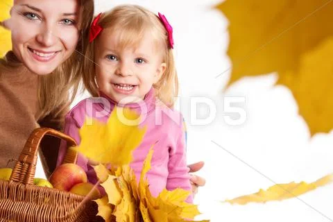 Mother and daughter with basket and leaves Stock Photos