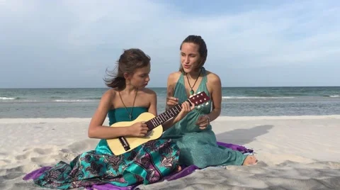 Mother and daughter, beach, playing guitar, daughter plays, singing together Stock Footage