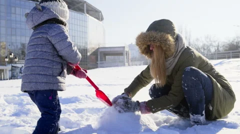 Mother and daughter building something of snow slow motion Stock Footage 59796103