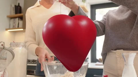 Mother and daughter cracking egg, starting whisking batter in kitchen while red Stock Footage 334183202