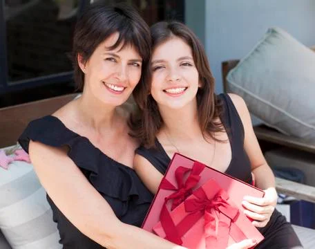 Mother and daughter with gifts sitting outdoors Stock Photos