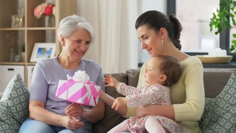 Mother and daughter giving grandmother present Stock Footage
