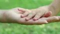 Mother and daughter hands on green background. Hand in hand HD Footage