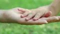 Mother and daughter hands on green background. Hand in hand HD Footage