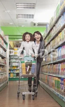 Mother and Daughter Having Fun in Supermarket, Pushing Cart Stock Photos