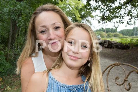 Mother and daughter hugging in love playing in the park Stock Photos