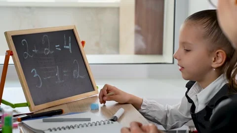 Mother and daughter learning maths at home, close-up. Video stock 273566844