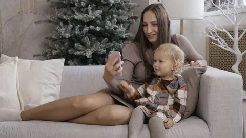 Mother and daughter make phone calls, communicate via video, use a smartphone Stock Footage