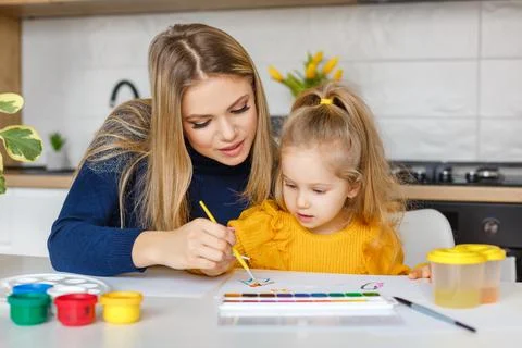 Mother and daughter painting at home Stock Photos