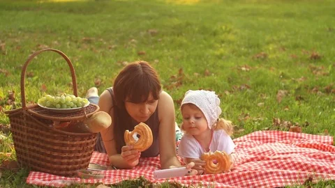 Mother and daughter on a picnic at sunset Stock Footage