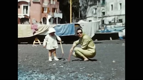 Mother and daughter play with sand, shovel, rake in the 60s Stock Footage 205592353