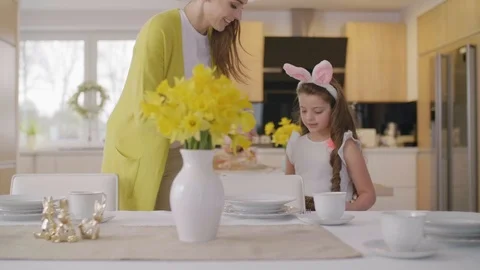 Mother and daughter setting table for easter brekfast Stock Footage 86423970