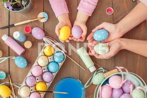 Mother and daughter together at home easter preparation top view holding colored Stock Photos