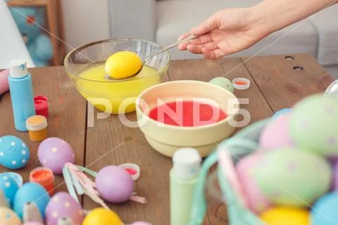 Mother and daughter together at home easter preparation coloring egg in water Stock Photos