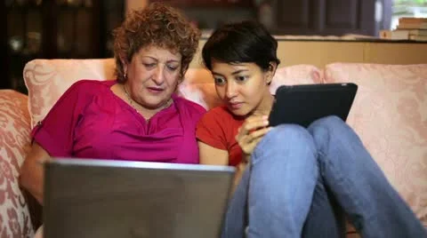 Mother and daughter using tablet computer together at home Stock Footage 12174026