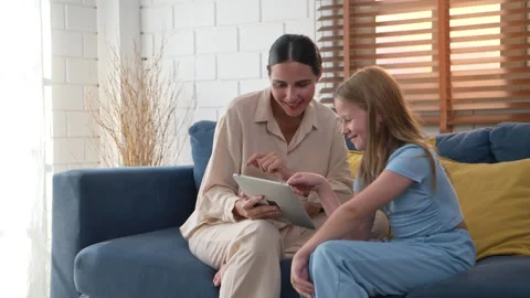 Mother and daughter using tablet together, enjoying digital learning Video stock 340143312
