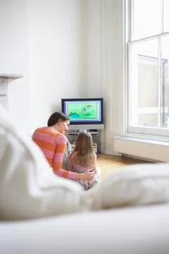 Mother And Daughter Watching Cartoons In TV Stock Photos