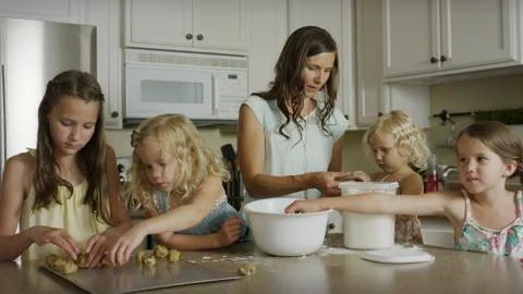 Mother and daughters baking cookies together in kitchen 스톡 사진