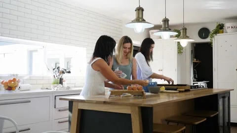 Mother and daughters baking together in contemporary kitchen Stock Footage 130659426