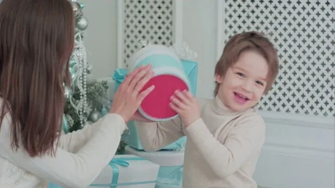 Mother and happy son checking gifts sitting near the Christmas tree Stock Footage 70376967