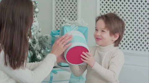Mother and happy son checking gifts sitting near the Christmas tree Stock Footage 152831540