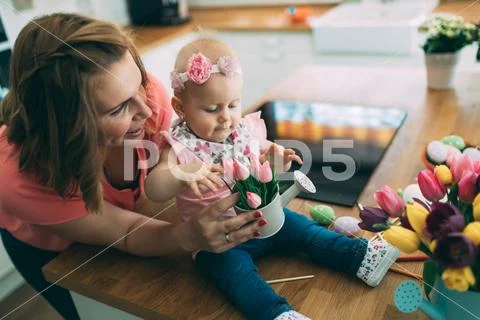 Mother and her baby painting easter eggs Stock Photos