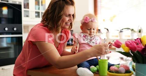 Mother and her baby painting easter eggs Stock Photos