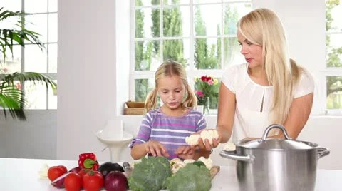 Mother and her daughter juggling with vegetables Stock Footage