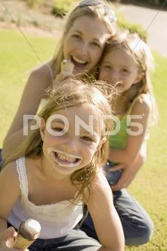 A mother and her daughters eating ice cream Stock Photos