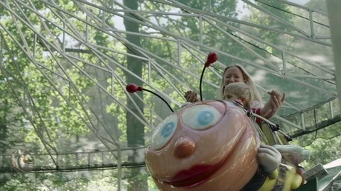 Mother and her little baby boy are riding on caterpillar in the amusement park Stock Footage