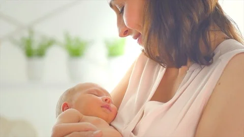 Mother and her newborn baby. Happy mom kissing and hugging her baby Stock Footage