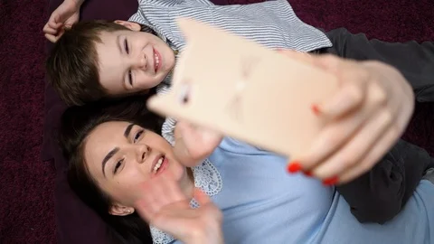 Mother and her son making a selfie or video call to father or relatives on the c Stock Footage 129389767