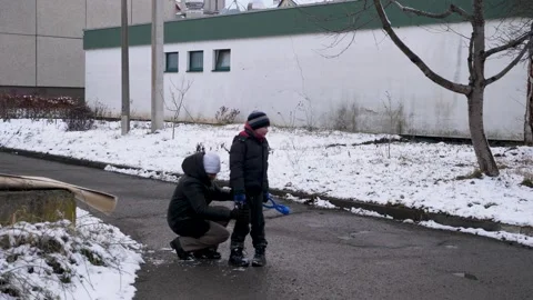 A mother and her son put their snowy clothes in order. Stock Footage 303200358