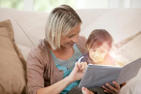 Mother and her son reading a glowing story together Stock Photos