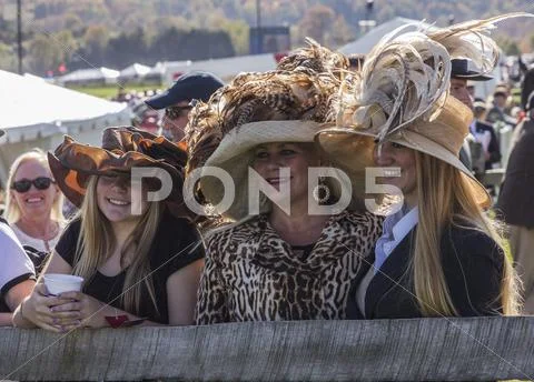 Mother and her young daughters wait for the hat contest Stock Photos